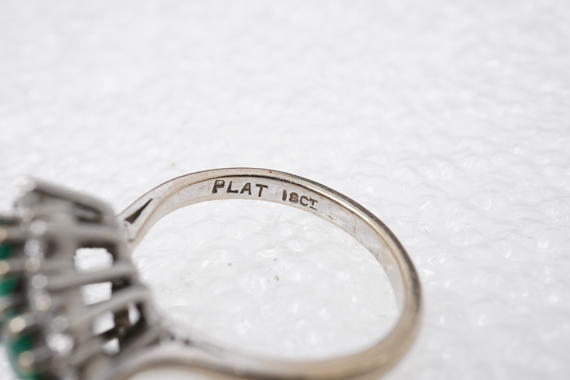 An emerald and diamond cluster ring